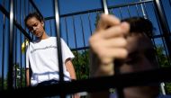 Teenagers are seen in a cage during a protest of international labor groups, civil society and students against the policy of migrant family separation along the US-Mexico border on June 17, 2019 in front of the United Nations offices in Geneva. / AFP / F
