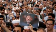 A man holds a picture of the former Egyptian president Mohamed Mursi during a symbolic funeral prayer at the courtyard of Fatih Mosque in Istanbul, Turkey, June 18, 2019. Reuters/Murad Sezer 