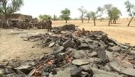 A soldier stands near debris from destroyed homes at the site of an ethnic massacre in which gunmen killed dozens of people, in the Dogon village of Sobane Da, Mali June 13, 2019, in this still image taken from video.