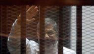 Ousted Egyptian President Mohamed Morsi standing inside a glass defendant's cage during first session in the trial where Morsi and 10 other co-defendants face on charges of spying for Qatar, in Cairo, Egypt.  Ahmed Omar - Anadolu