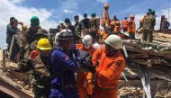 Rescue workers remove a victim from the debris after an under-construction building collapsed in Sihanoukville on June 22, 2019.  / AFP / Den AYUTHYEA 