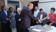President Recep Tayyip Erdogan (C) shakes hands as he casts his vote, flanked by Finance Minister Berat Albayrak (L) and his wife Esra Erdogan (2nd L), at a polling station during the mayoral election re-run in Istanbul on June 23, 2019.  AFP / Adem ALTAN