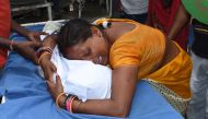 An Indian woman mourns with the wrapped up body of Muskan Sahni who had earlier died from Acute Encephalitis Syndrome (AES) at the government-run Sri Krishna Medical College and Hospital in Muzaffarpur district in the eastern state of Bihar on June 19, 20