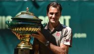 Roger Federer from Switzerland poses with the trophy after he won his final match against David Goffin from Belgium at the ATP tennis tournament in Halle, western Germany, on June 23, 2019. / AFP / CARMEN JASPERSEN
