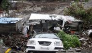 A damaged vehicle is seen at the site of a wall collapse in Pune on June 29, 2019.  AFP / STR