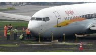 A SpiceJet aircraft is surrounded by airport staff as it stands stranded off the tarmac at Chhatrapati Shivaji Maharaj International Airport in Mumbai on July 2, 2019, after it overran the runway while landing during heavy rain, causing no injuries. / AFP