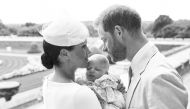 This official handout Christening photograph released by the Duke and Duchess of Sussex shows Britain's Prince Harry, Duke of Sussex (R), and his wife Meghan, Duchess of Sussex holding their baby son, Archie Harrison Mountbatten-Windsor at Windsor Castle 