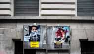 A picture shows vandalised campaign posters of Emmanuel Macron and Marine Le Pen in Lyon on May 1, 2017 ahead of  final round of the presidential election. AFP/Jeff Pach