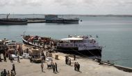 FILE PHOTO: Workers stand at the sea port of the coastal town of Kismayu in southern Somalia November 12, 2013. REUTERS/Siegfried Modola/File Photo