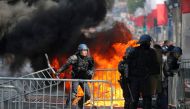 French Gendarmes remove fences next to a burning portable toilet during clashes with protesters on the Champs Elysees avenue after the traditional Bastille Day military parade in Paris, France, July 14, 2019. Reuters/Pascal Rossignol
