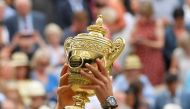 Novak Djokovic poses with the trophy as he celebrates winning the final against Switzerland's Roger Federer. Reuters/Toby Melville