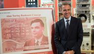 Mark Carney, governor of the Bank of England, poses for a photograph beside the concept design for the new Bank of England fifty pound banknote, featuring mathematician and scientist Alan Turing, during the presentation at the Science and Industry Museum 