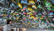 Visitors view a hanging art installation by a group of artists made from scraps of plastics, cans and containers at an exhibition 