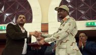 Deputy Head of Sudanese Transitional Military Council, Mohamed Hamdan Dagalo and opposition alliance signed coalition's leader Ahmad al-Rabiah shake hands after signing a political accord as part of a power-sharing deal aimed at leading the country to dem