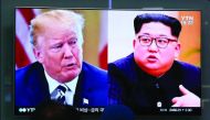 People watch a TV screen showing images of US President Donald Trump and North Korean leader Kim Jong-Un at a railway station in Seoul.