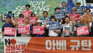 South Korean protesters holding placards reading 