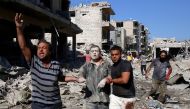 Syrians help a man pulled out from the rubble of a destroyed building following a Russian air strike on July 22, 2019 on Maaret al-Numan in Syria's northwestern Idlib province in the latest violence to plague the opposition bastion, as the Damascus regime