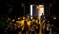 Men in white T-shirts and carrying poles are seen in Yuen Long after attacking anti-extradition bill demonstrators at a train station in Hong Kong, China, July 22, 2019. Reuters/Tyrone Siu