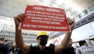 A demonstrator holds a banner during a protest against the recent violence in Yuen Long, at Hong Kong airport, China July 26, 2019. REUTERS/Edgar Su