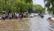 Commuters make their way on a flooded street after heavy monsoon rains in Hyderabad on July 31, 2019, some 160km east of the southern port city of Karachi. / AFP / AKRAM SHAHID