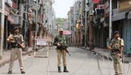 Indian security personnel stand guard along a deserted street during restrictions in Jammu, August 5, 2019. (REUTERS/Mukesh Gupta)