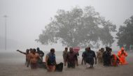 Members of a rescue team wade through a water-logged area during heavy rains on the outskirts of Kochi in the southern state of Kerala, India, August 8, 2019. (REUTERS/Sivaram V)