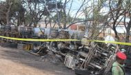 Police tape cordons off the area where the carcass of a burnt-out fuel tanker is seen along the side of the road following an explosion on August 10, 2019, in Morogoro, 200 kilometres (120 miles) west of the Tanzanian capital Dar es Salaam.  AFP / STRINGE