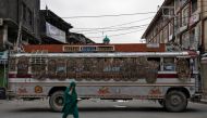 File photo of a Kashmiri woman walks past a bus used as a road block by Indian security personnel during restrictions after the scrapping of the special constitutional status for Kashmir by the government, in Srinagar, August 11, 2019. REUTERS/Danish Sidd