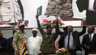Sudan's protest leader Ahmad Rabie (2nd-R), flashes the victory gesture alongside General Abdel Fattah al-Burhan (C), the chief of Sudan's ruling Transitional Military Council (TMC), during a ceremony where they signed a 