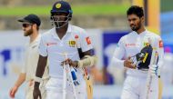 Sri Lanka's cricketer Angelo Mathews (C), teammate Dhananjaya de Silva (R) and New Zealand's cricket captain Kane Williamson (L behind) leave the field after Sri Lanka beat New Zealand in first Test by six wickets during the final day of the opening Test 