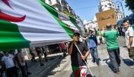 Algerian demonstrators chant slogans and march with national flags as they gather in the streets of the capital Algiers against the ruling class amid an ongoing political crisis in the country, on the 26th consecutive Friday of protests on August 16, 2019