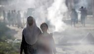 Kashmiri girls walk amidst smoke during clashes between Indian security forces and protestors, after scrapping of the special constitutional status for Kashmir by the Indian government, in Srinagar, August 23, 2019. (REUTERS/Adnan Abidi)
