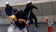 A demonstrator throws back a tear gas canister as they clash with riot police during a protest in Hong Kong, China, August 24, 2019. REUTERS/Kai Pfaffenbach