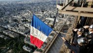 FILE PHOTO: Paris firemen display a French national flag on the balcony of the Eiffel Tower in Paris, in memory of their 1944 colleagues who did it on the day Paris was liberated from Nazi occupation. AFP / PIERRE VERDY
