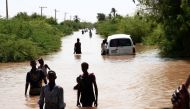 Sudanese people walk a flooded road in Wad Ramli village on the eastern banks of the Nile river on August 26, 2019. AFP / Ebrahim HAMID