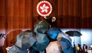 A protester defaces the Hong Kong emblem after they broke into the government headquarters in Hong Kong on July 1, 2019 on 22nd anniversary of the city handover from Britain to China. AFP /Philip Fong