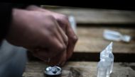 A drug addict prepares cocaine for injection in a small wooded area used by addicts to take drugs near Glasgow city centre, Scotland, on August 15 2019. AFP / Andy Buchanan