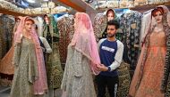 A Kashmiri shopkeeper displays a wedding dress at a market ahead of the Muslim festival of Eid al-Fitr in Srinagar on June 3, 2019. AFP / Tauseef Mustafa