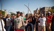 Zulu residents of the Jeppe Men Hostel scream waving batons in the Johannesburg CBD on September 3, 2019, after South Africa's financial capital was hit by a new wave of anti-foreigner violence. AFP / Michele Spatari