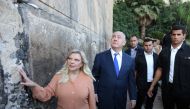 Israeli Prime Minister Benjamin Netanyahu looks up while his wife Sara touches the outside wall of the Cave of the Patriarchs, a shrine holy to Jews and Muslims during a state memorial ceremony, in Hebron in the Israeli-occupied West Bank September 4, 201