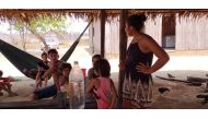 Members of the Tenharim indigenous community gather under a thatched roof in the state of Amazonas, Brazil, Sept. 1, 2019. Thomson Reuters Foundation/Fabio Teixeira