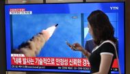 A woman walks past a television news screen showing file footage of a North Korean missile launch, at a railway station in Seoul on September 10, 2019. AFP / Jung Yeon-je