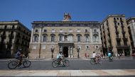 People cycle across Sant Jaume square in Barcelona, Spain, August 4, 2017. Reuters/Albert Gea