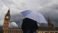 A woman looks towards dark clouds over the Houses of Parliament in central London, August 11, 2014 . Reuters / Luke MacGregor