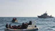 In this file photo taken on February 18, 2019, a handout image made available by France's Societe Nationale de Sauvetage en Mer (SNSM) on February 18, 2019, shows British rescuers (front) helping some 20 migrants on a semi-rigid boat trying make their way