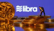 FILE PHOTO: A small toy figure stands on representations of virtual currency in front of the Libra logo in this illustration picture, June 21, 2019. REUTERS/Dado Ruvic/Illustration/File Photo