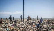 People walk among rubble of demolished houses in Xwlacodji, in the 5th arrondissement of Cotonou on September 3, 2019, after the passage of bulldozers. AFP / Yanick Folly