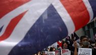 Anti-government protesters hold up banners, placards, Union Jack flags as they gather at the British consulate General in Hong Kong, China, September 15, 2019. REUTERS/Athit Perawongmetha