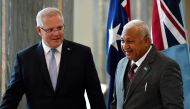 Australia's Prime Minister Scott Morrison (L) invites his Fijian counterpart Frank Bainimarama to sign a visitors book at Parliament House in Canberra on September 16, 2019.  / AFP / POOL / MICK TSIKAS 