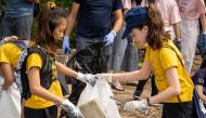 12-year-old Ralyn Satidtanasarn (L), known as Lilly, collects plastic waste during the Trash Hero cleaning initiative at the Khung Bang Kachao urban forest and beach in Bangkok on August 25, 2019.  AFP / Mladen Antonov